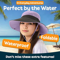 A girl enjoys the beach in a lavender GearTOP sun hat for kids, featuring waterproof, foldable design and UPF 50+ sun protection.
