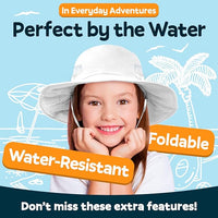 Smiling child wearing the GearTOP white kids sun hat by the water, showing its UPF 50+ sun protection, water-resistant fabric, foldable design, and lightweight comfort.
