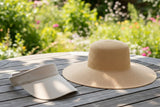 Sun visor hat next to wide-brim UPF 50+ sun hat on outdoor table, showing coverage difference