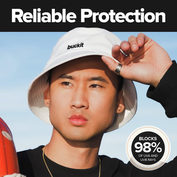 Model wearing the white Clean Slate Bucket Hat outdoors, demonstrating reliable UPF 50+ sun protection that blocks 98% of harmful UVA and UVB rays.