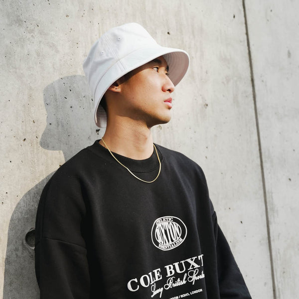 Model wearing the white Clean Slate Bucket Hat made from premium cotton twill, showcasing its lightweight, breathable comfort and versatile everyday streetwear style.