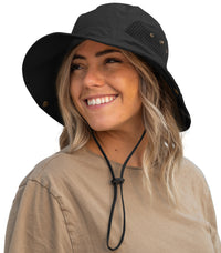 Woman wearing the GearTOP Floater Series black wide brim sun protection hat featuring UPF 50+ UV protection, breathable mesh side panels, waterproof construction, and an adjustable chin strap for hiking, fishing, and boating.