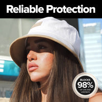 Woman wearing a white suede bucket hat with a wide brim that provides stylish everyday sun protection for travel, festivals, beach days, and outdoor activities.